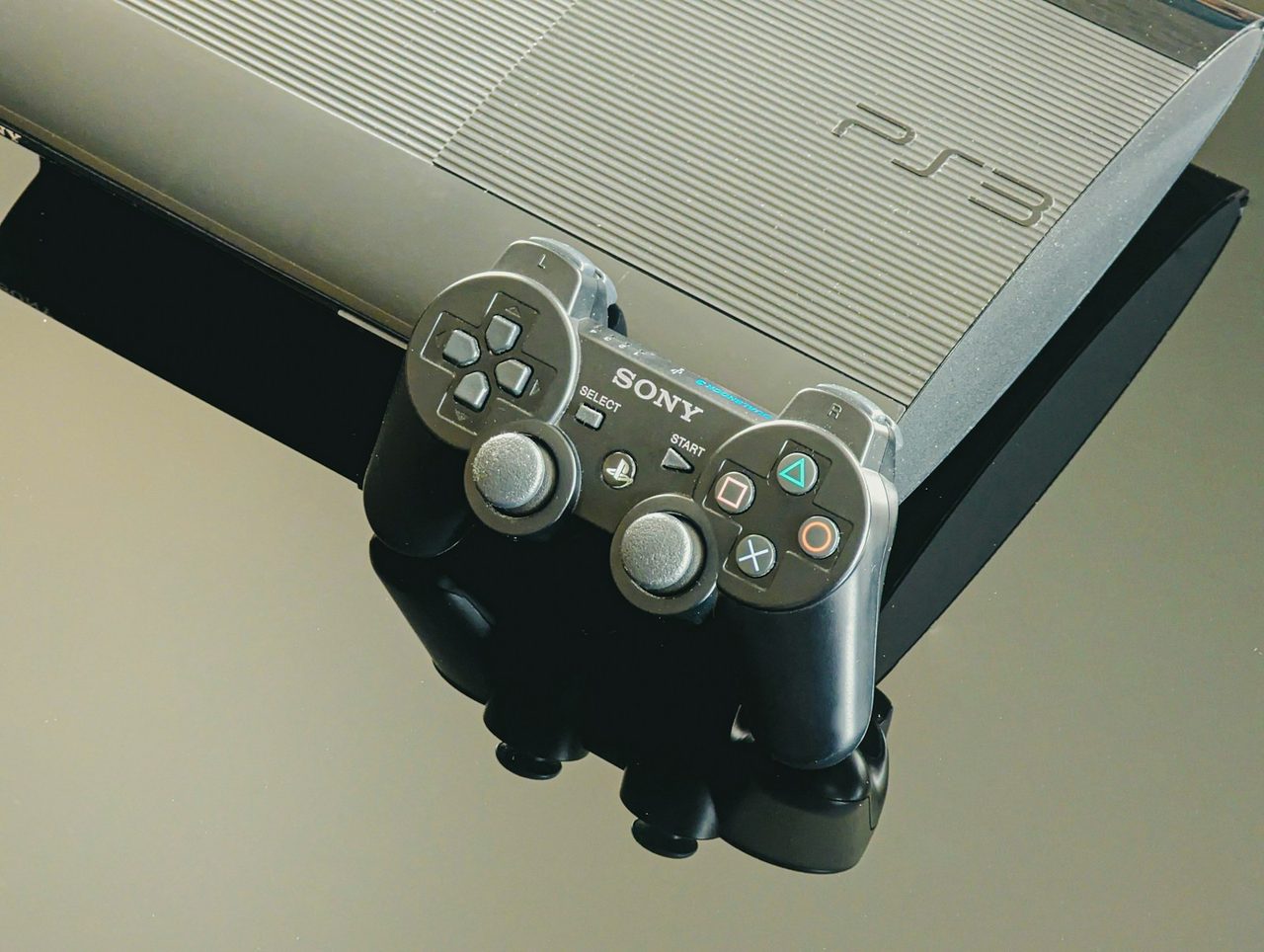 Console de salon et manette filaire posées sur une surface sombre