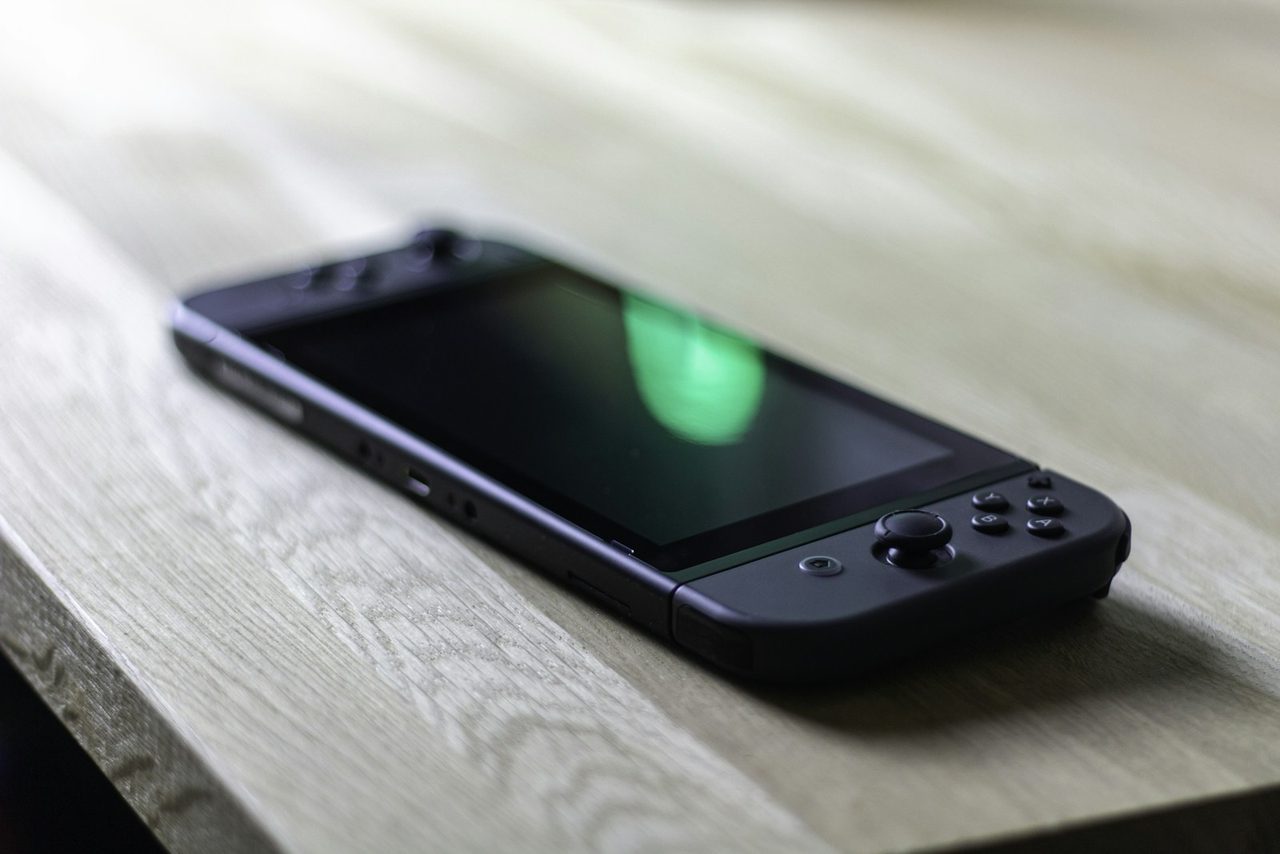 Console portable ouverte sur un plan de travail, jeu inséré