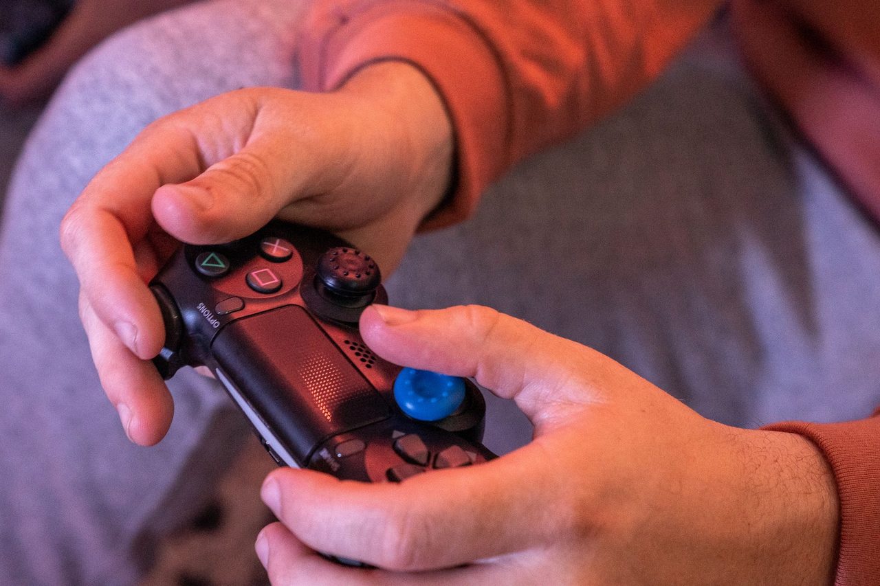 Mains sur une manette de jeu, pouces sur les sticks